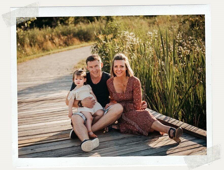 The Happy Sprouts family sitting together on a wooden boardwalk